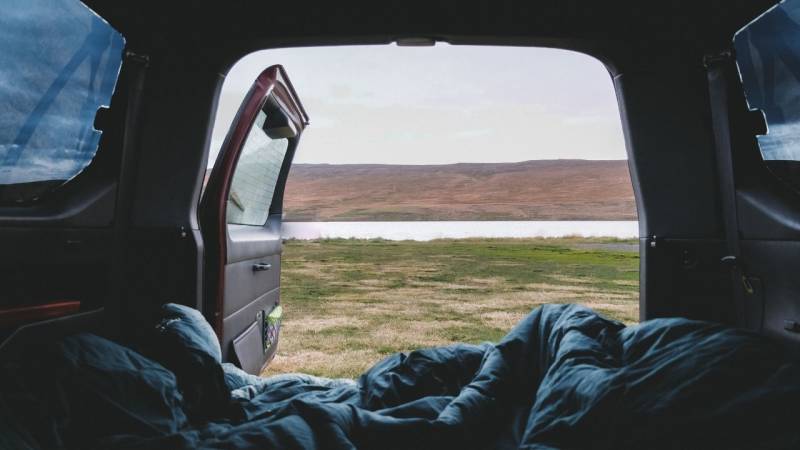 A thick blanket and a sleeping bag are a must when camping in the car