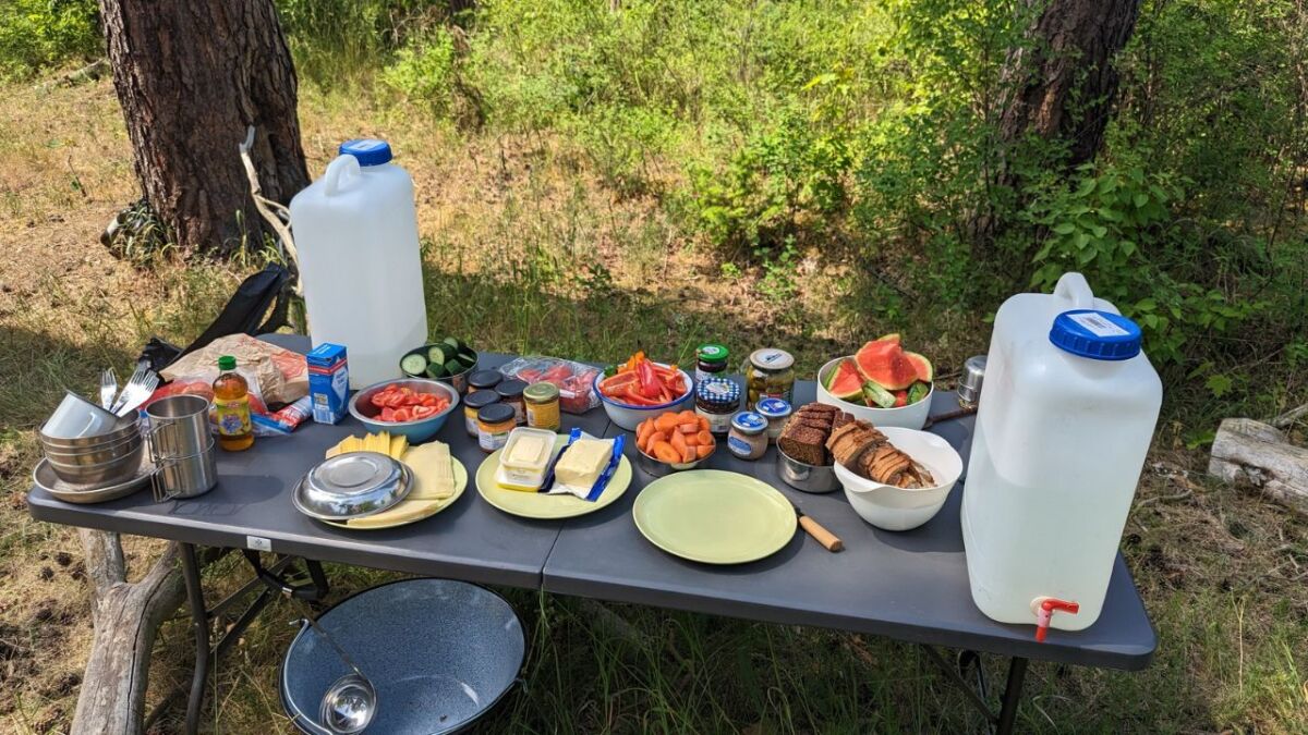 Camping table with water canisters and food