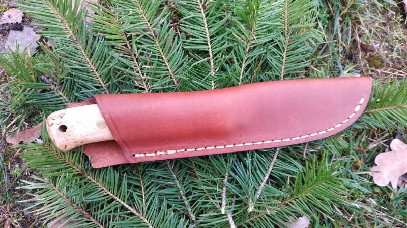 Ein Bushcraft-Messer in einer Lederscheide