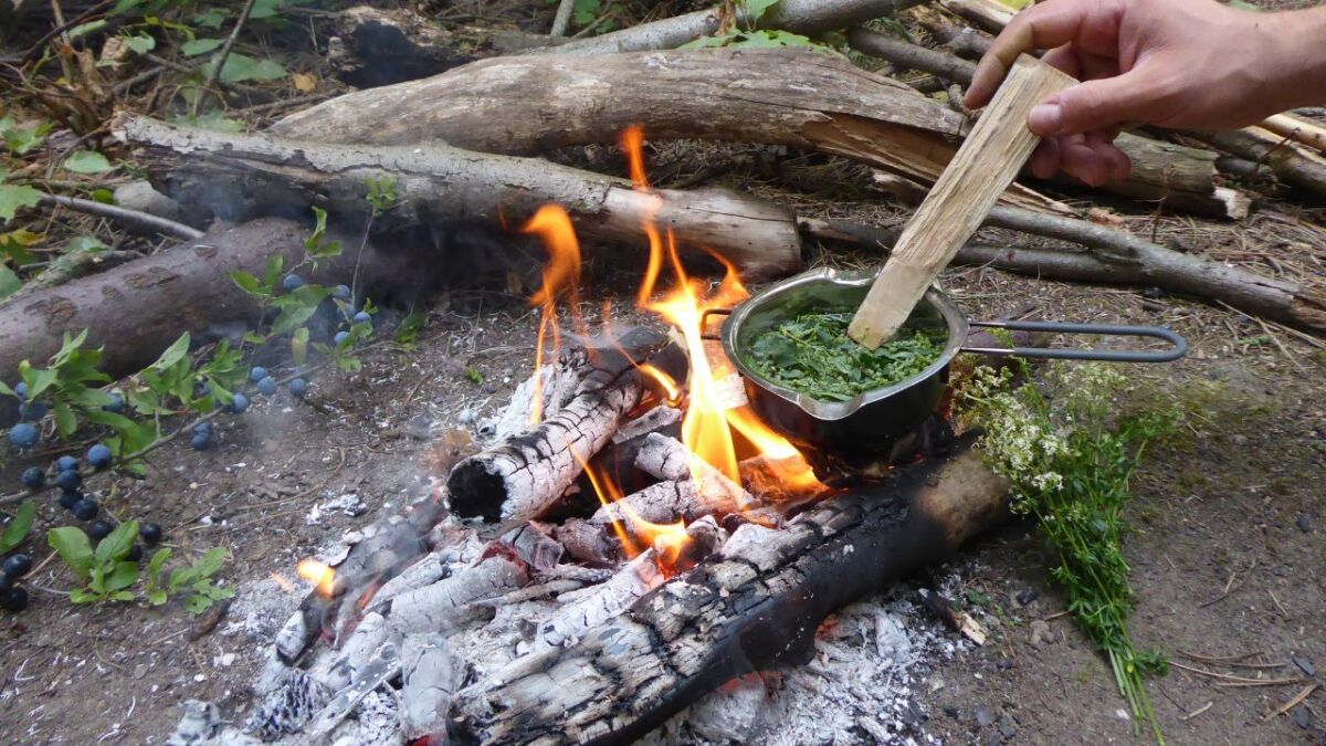 feuer machen mit topf suppe aus pflanzen