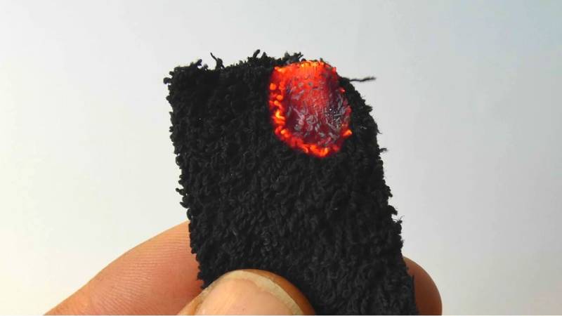 Glowing charred cotton ignites within seconds with a magnifying glass