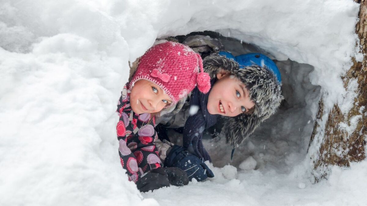 kinder schauen aus der schneehoehle