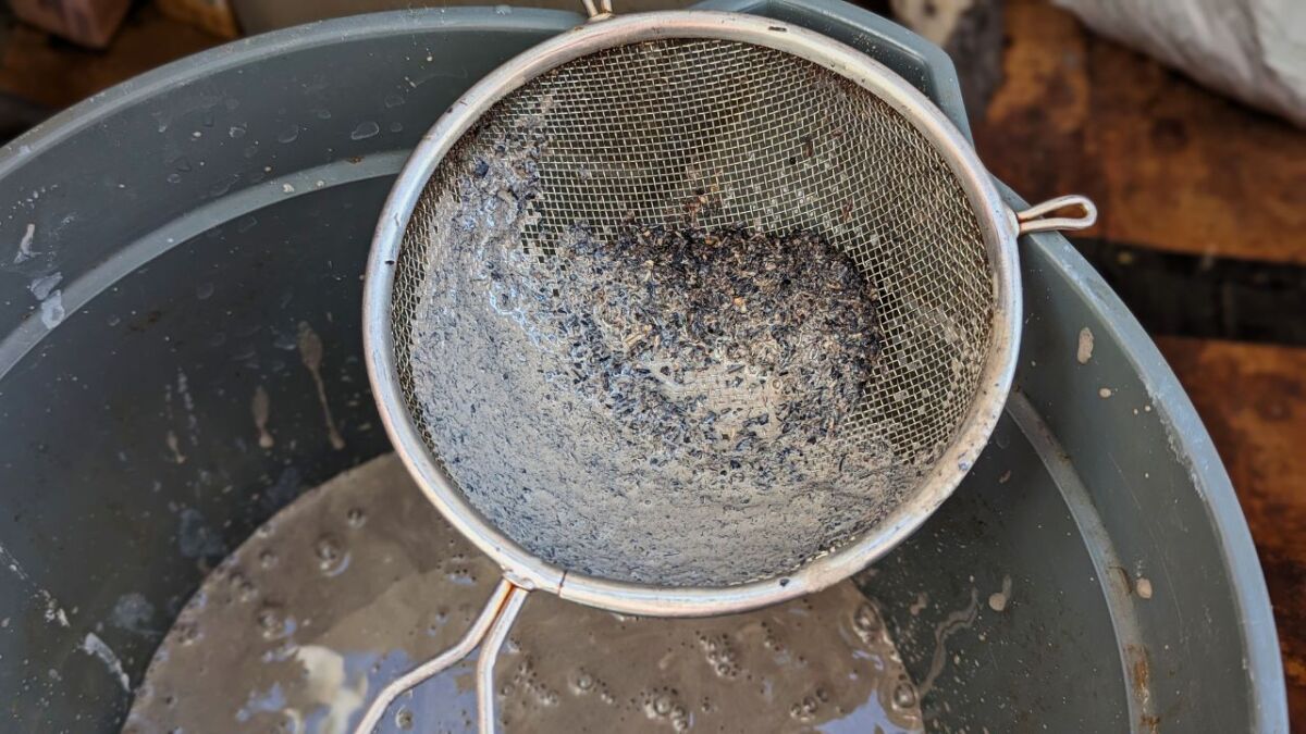 Using a fine sieve, I remove further dirt particles from the clay water