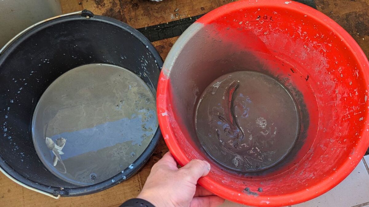 On the left is the clay-water mixture and on the right in the bucket the remaining sand on the bottom