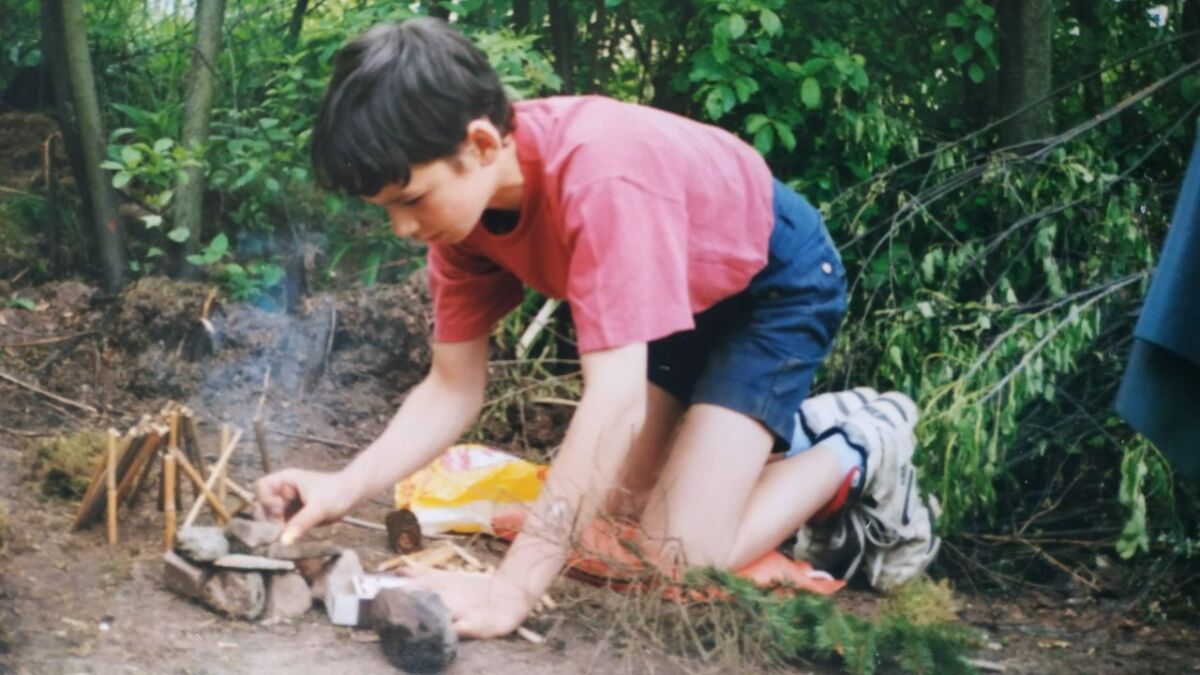 Martin Gebhardt, Wildnis-Mentor, im Garten als Kind beim Feuer machen