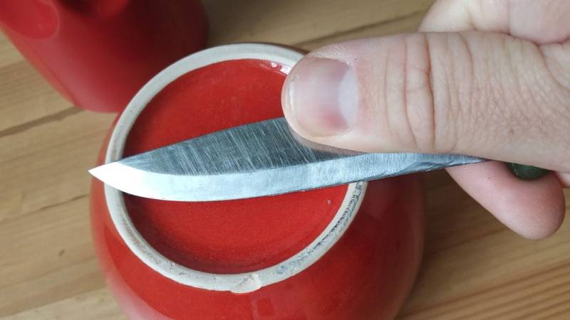 The unglazed bottom of a porcelain cup is perfect for sharpening a knife