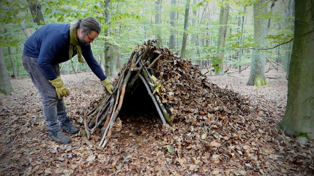 unterschlupf bauen aus blaettern und aesten