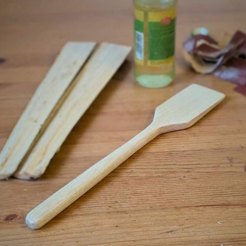 Hände schnitzen einen Holzspatel aus Ahorn